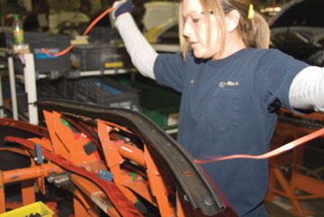 Many Shades of Green - A Subaru assembly line worker prepares to recycle plastic backing from door trim
