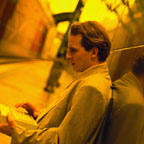 Man Waiting for Train with Laptop