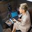 Business Woman Working at Pay Phone with Laptop