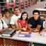 Group Of Students Leaning On Bookcase Looking Up