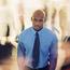 Man In Tie Standing In Blurred Crowd