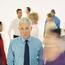 Man With Tie Standing To the Side In Blurred Crowd